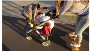 mom on hoverboard feeding baby in stroller