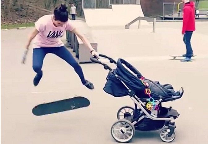 skateboarder does kick-flip while pushing baby stroller